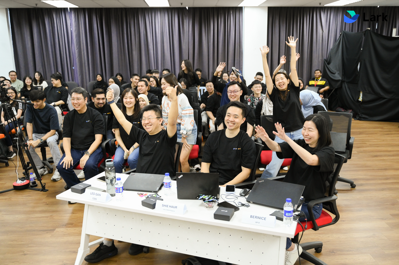 Audience engaging in team session with DIY employees raising hands and participating